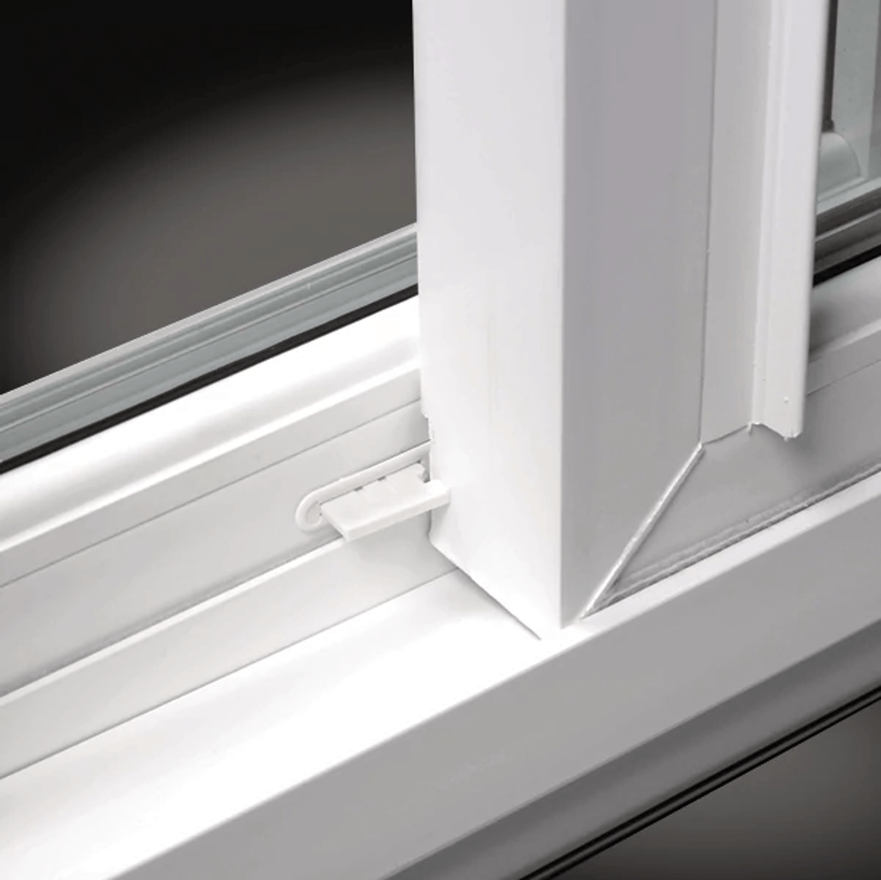 Close-up reference photo of white vinyl sliding window ventilation stops